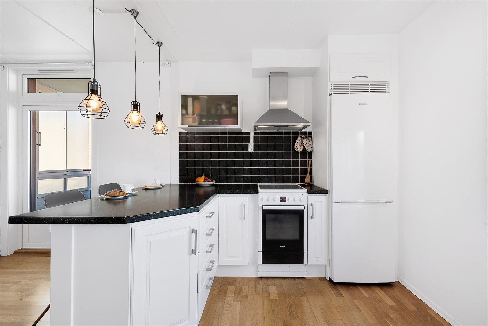 Praktisk kjøkken med elegante detaljer og god arbeidsflate.
Man har revet veggen mellom kjøkken og stue for å få en sosial og åpen løsning. Galleribilde