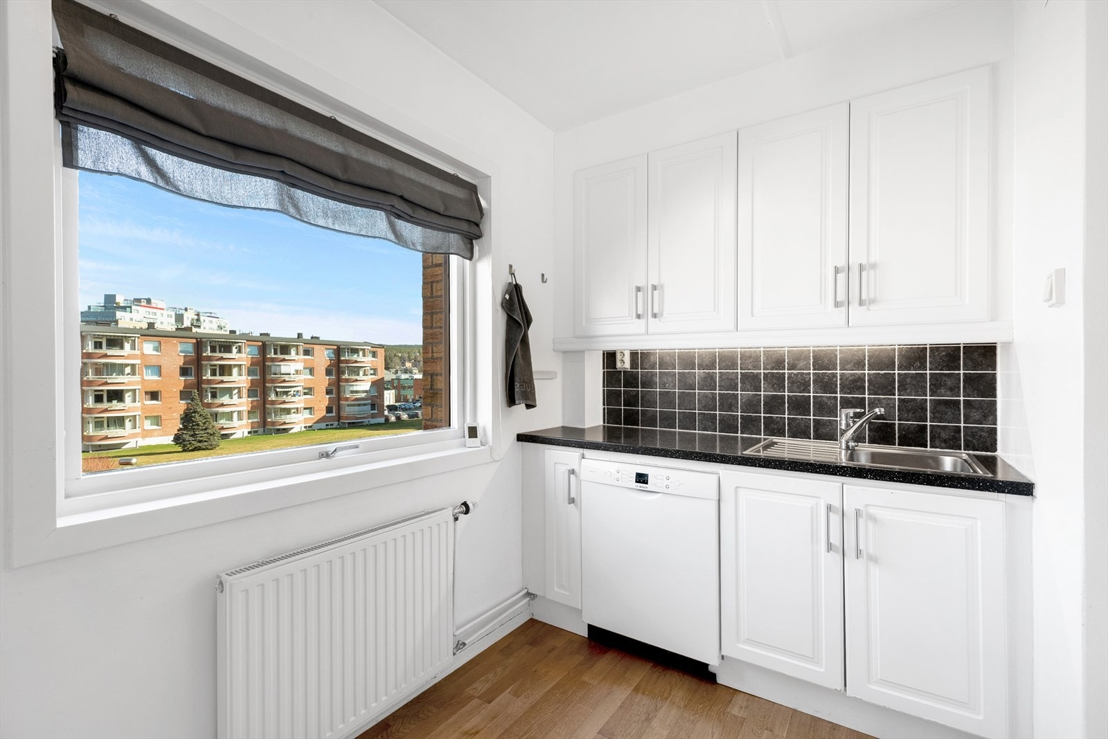 Funksjonelt kjøkken med utsikt mot koselig fellesområde. Galleribilde