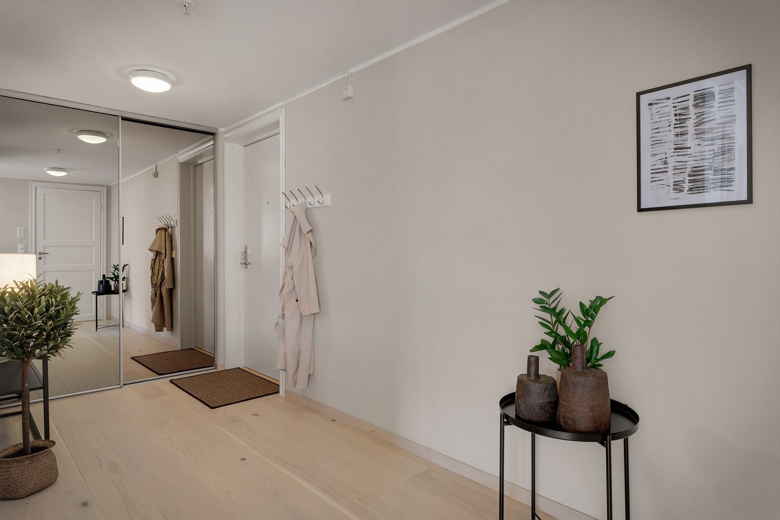 Lys éntre med garderobeskap av skyvbare speilfronter og plass til å henge fra seg yttertøyet Galleribilde
