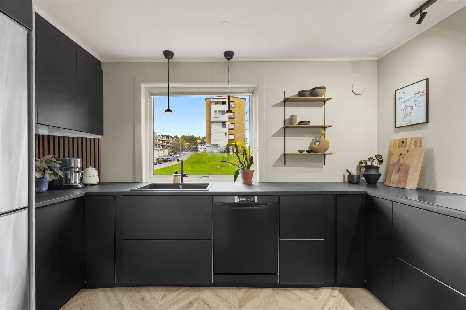 Integrerte hvitevarene inkluderer en induksjonstopp, stekeovn og oppvaskmaskin, som gir et sømløst og ryddig utseende. Galleribilde