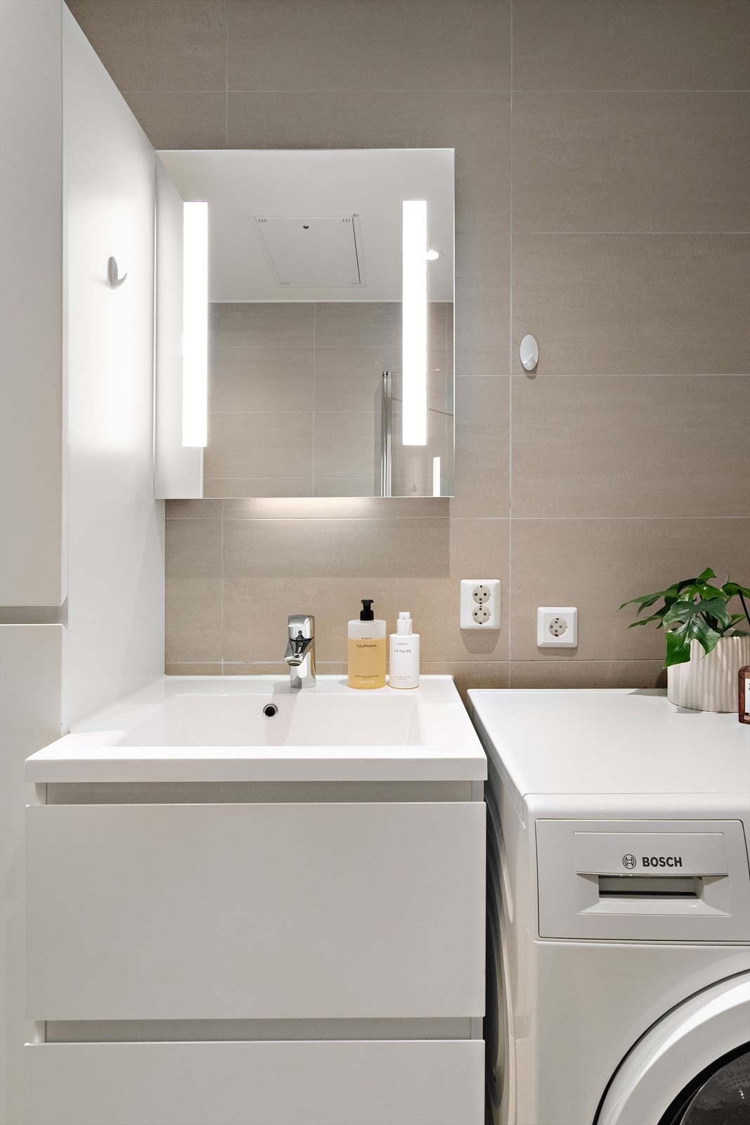 Bad med baderomsinnredning og sideskap med god oppbevaring Galleribilde