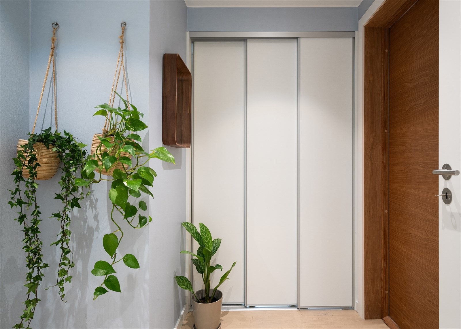 Praktisk og funksjonell entré med inngang til omkledningsrom bak skyvedør Galleribilde