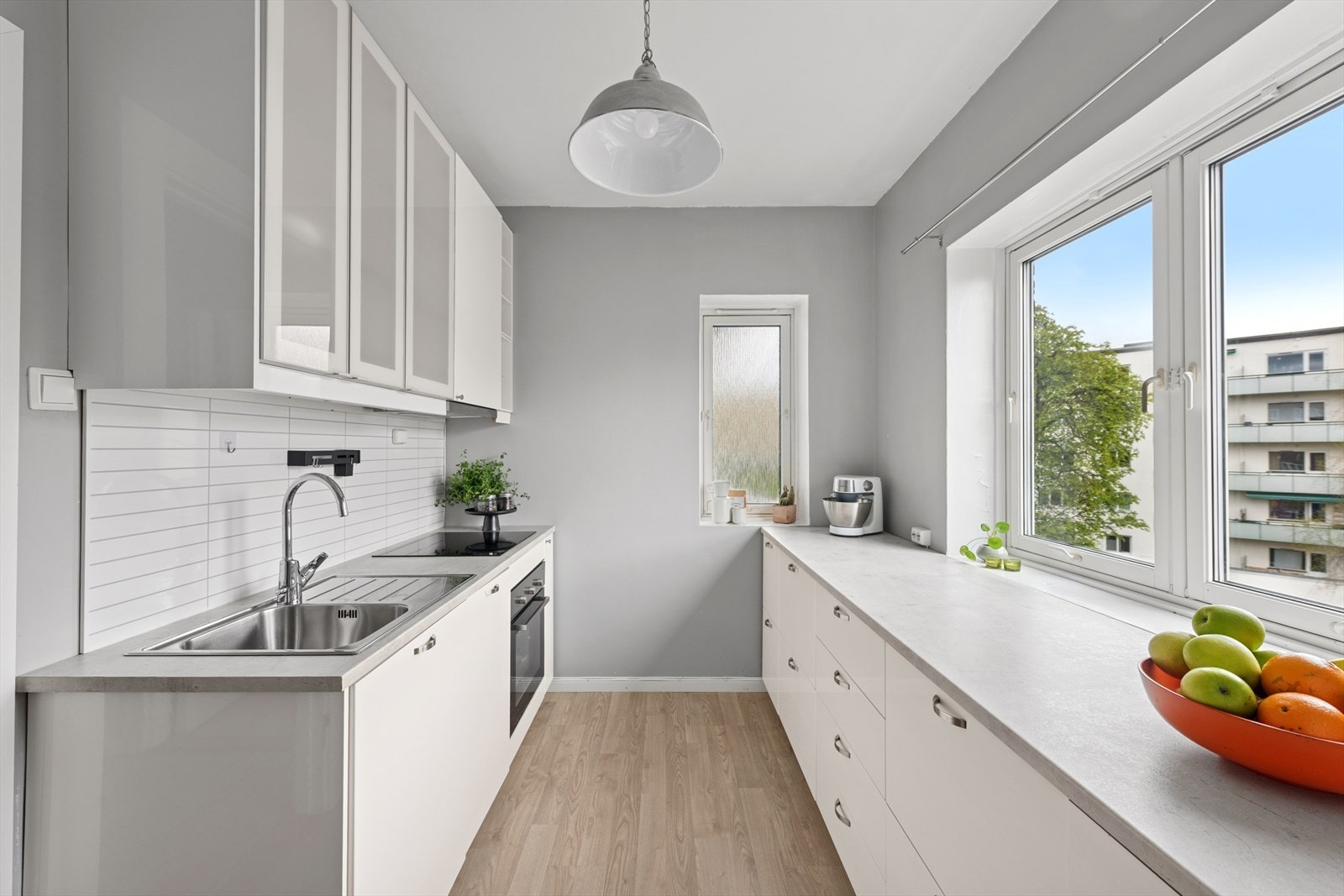 Minimalistisk design med fokus på funksjonalitet og rikelig oppbevaringsplass med gode lagringsmuligheter i over- og under-skap. Galleribilde