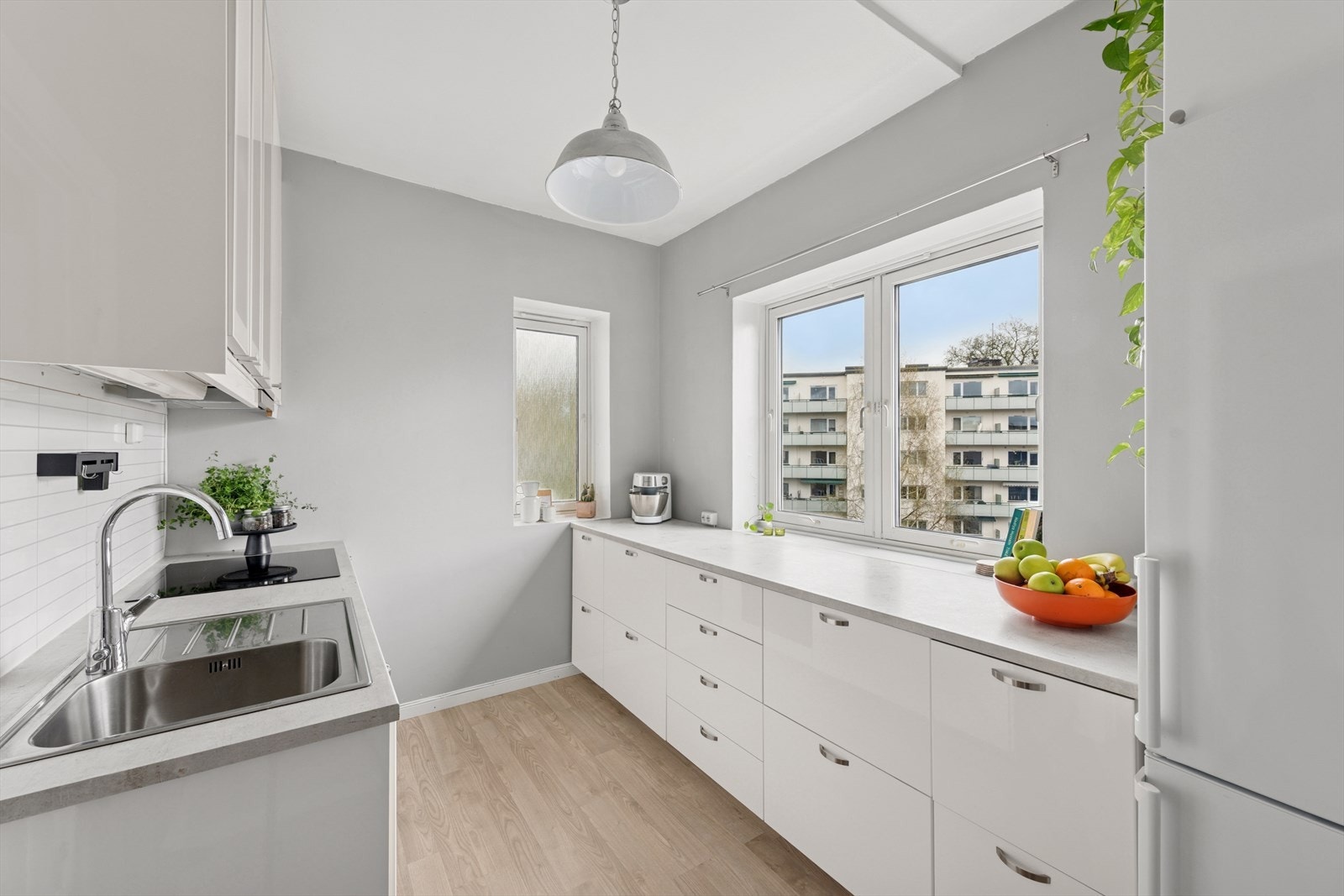 IKEA kjøkkeninnredning fra 2020 innredet med glatte, høyglans fronter, laminat benkeplate med nedfelt kum i rustfritt stål. Galleribilde