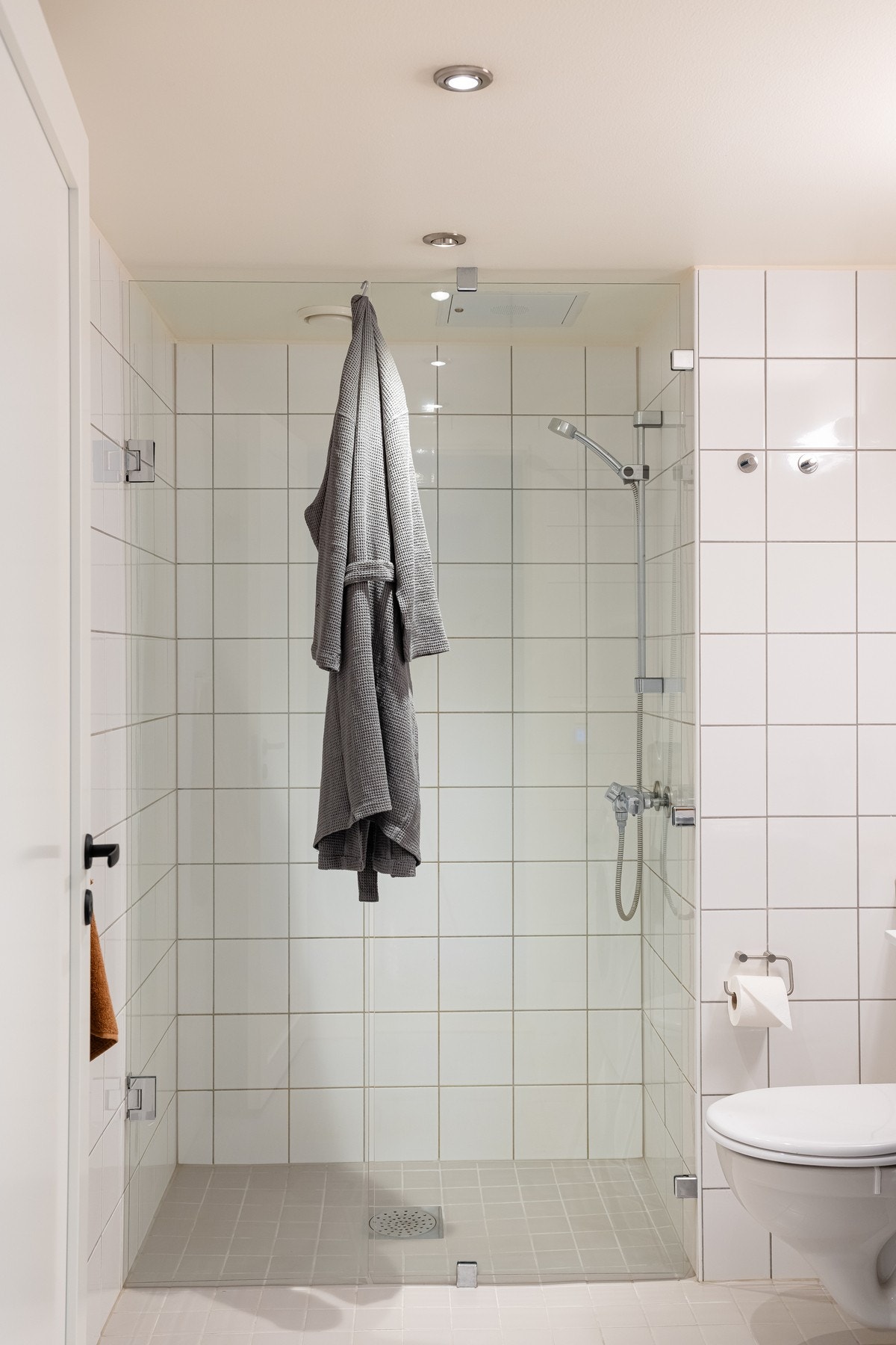 Videre er det vegghengt toalett og et romslig dusjhjørne med glassfelt og glassdør. Galleribilde