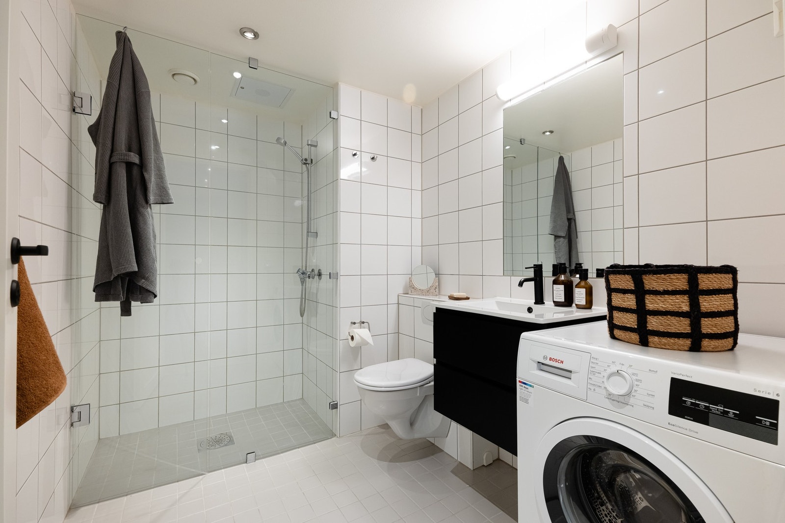 Boligens baderom er lyst, flislagt med varme i gulv og downlights i himling. Det er opplegg for vaskemaskin og plass til tørketrommel. Galleribilde