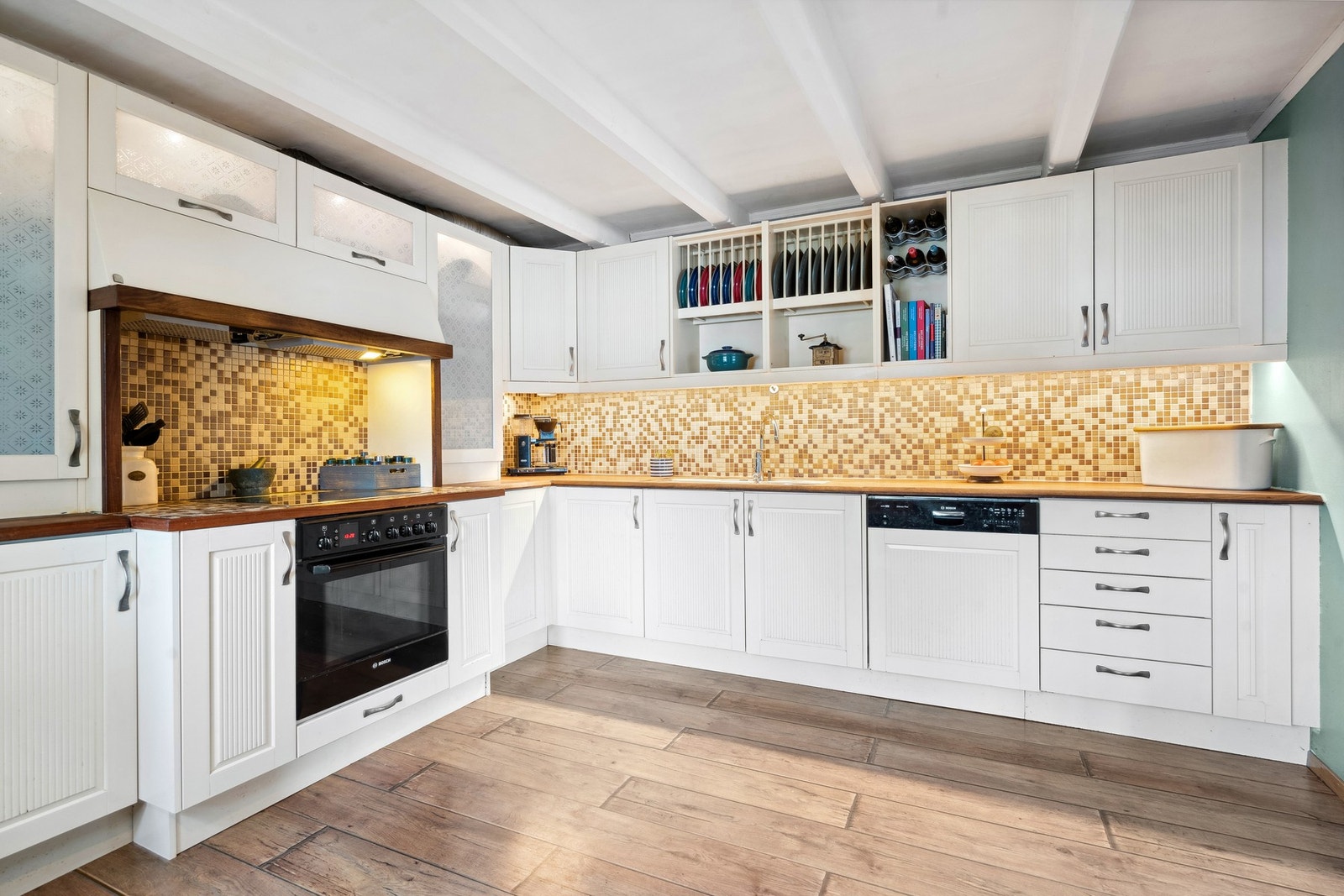 Klassisk kjøkken med malte fronter, heltre benkeplate, fliser og integrert ventilator. Galleribilde