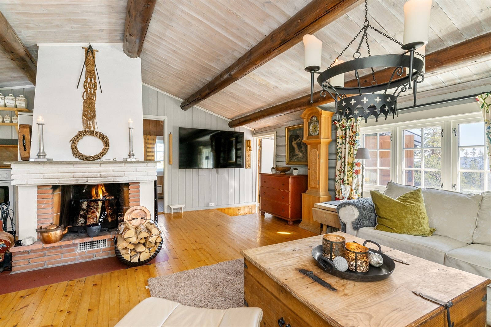 Midt i stuen står en stor og stemningsfull peis, som sørger for god varme til hytta. Galleribilde