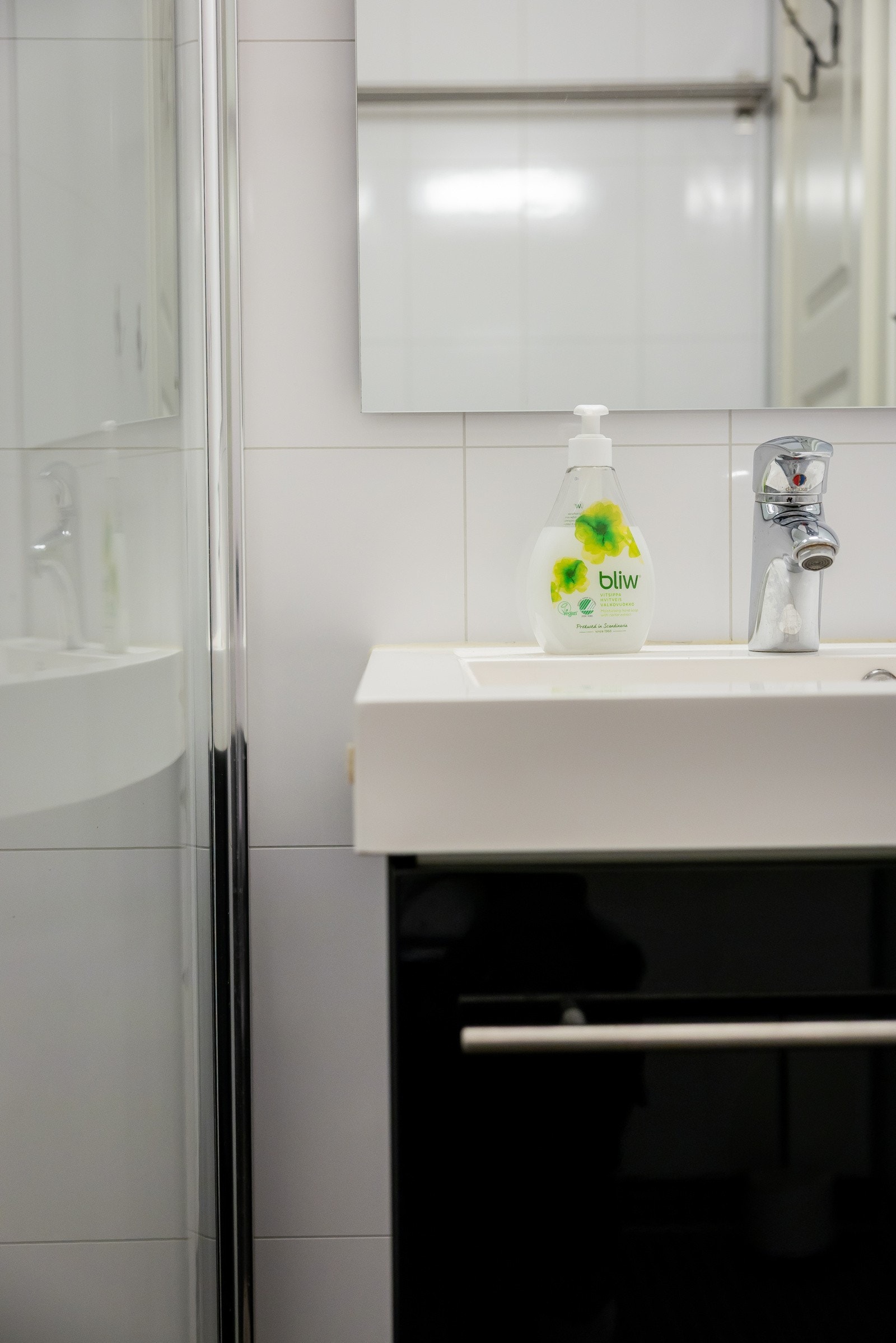 Badet er innredet med en baderomsinnredning med slette fronter, heldekkende servant og ett-greps blandebatteri, speil, vegglampe, vegghengt toalett og dusj med innfellbare dører i herdet glass samt dusjgarnityr med hånddusj. Der er elektriske varmekabler. Galleribilde