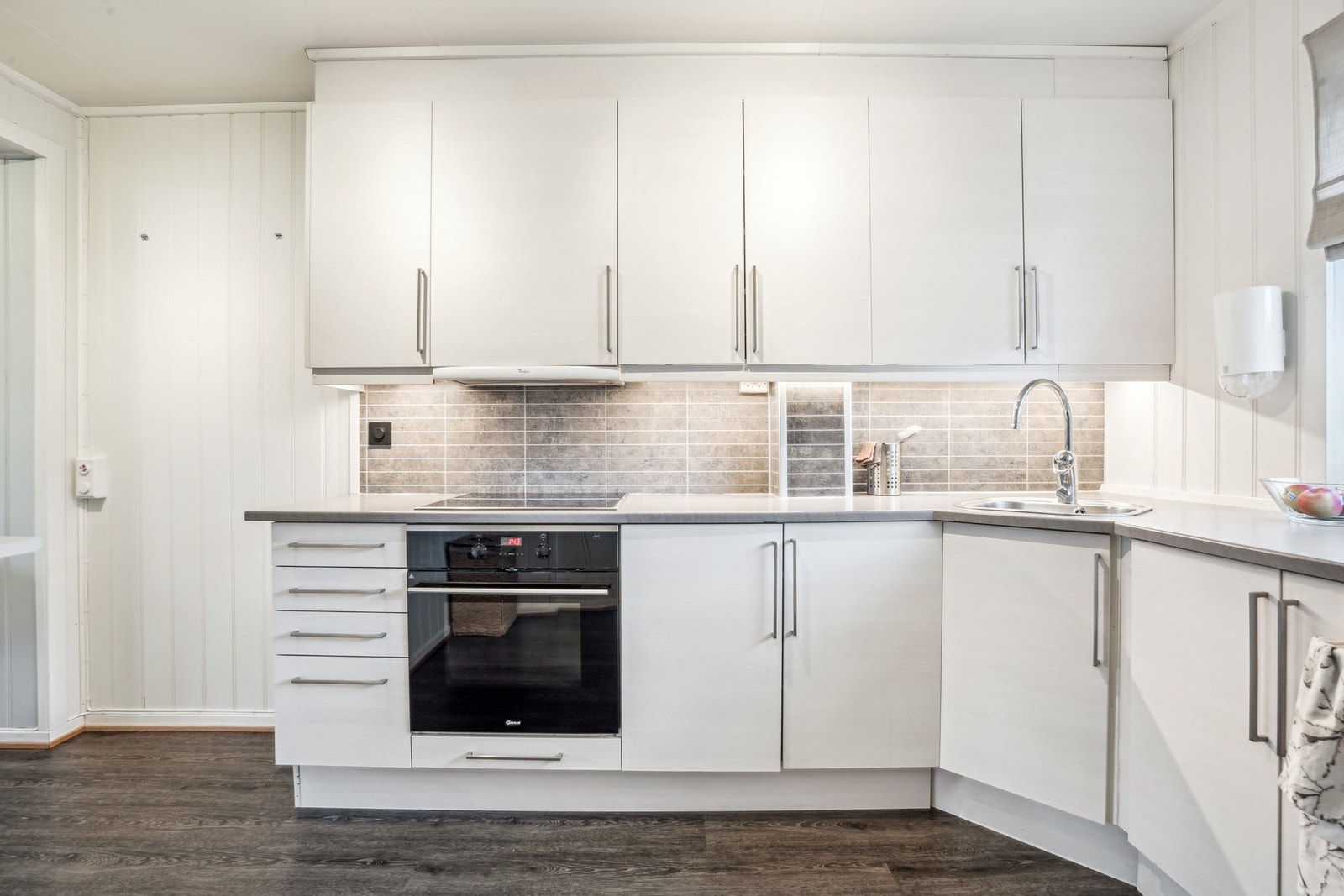 Kjøkkenet har innredning med glatte fronter. Benkeplaten er av laminat. Galleribilde