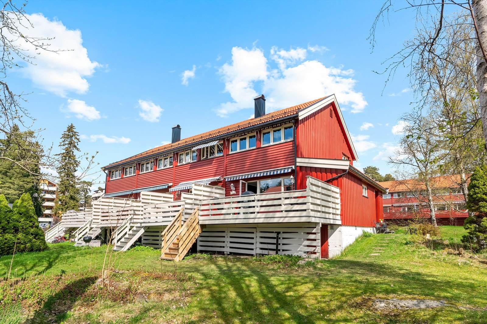 Terrassen vender ut mot et rolig, grønt fellesareal, med trapp ned til terreng. Galleribilde