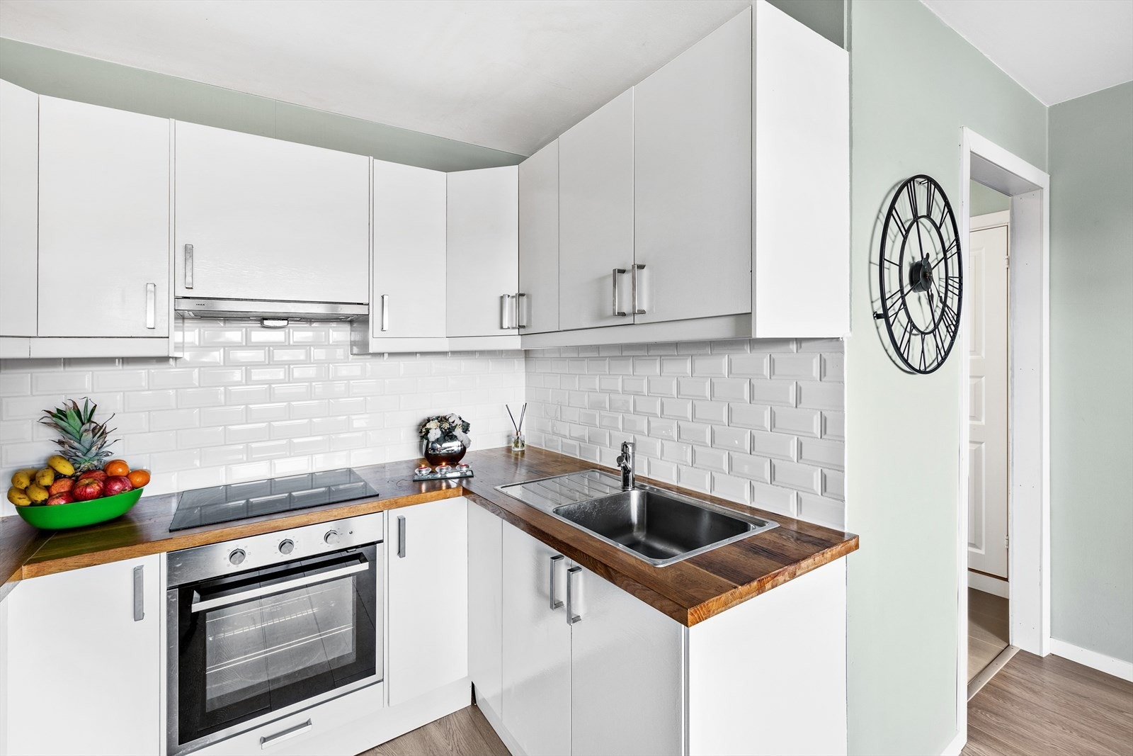 Kjøkkeninnredningen med glatte fronter, og heltre benkeplate med nedfelt kum i rustfritt stål. Galleribilde