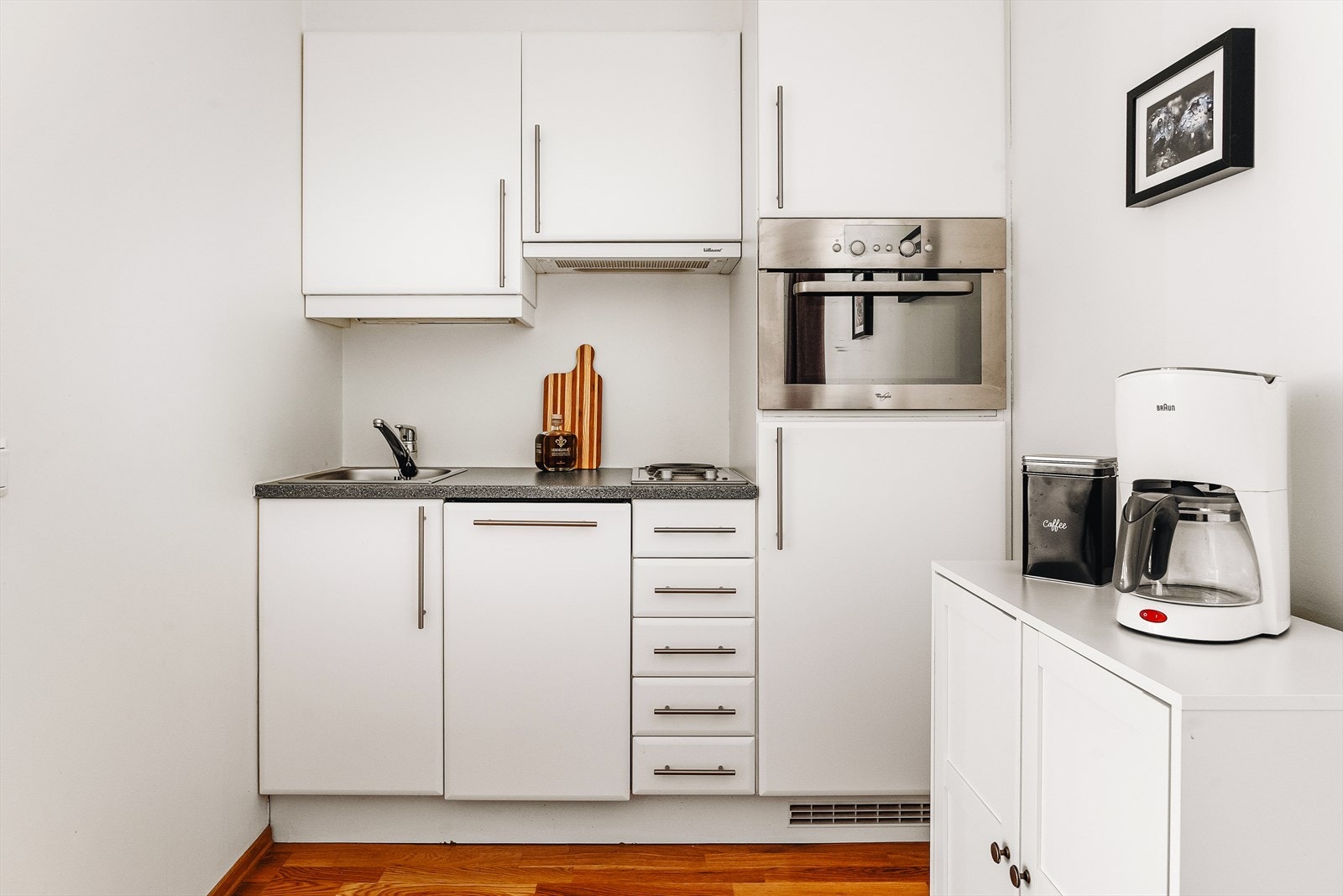 Kjøkkeninnredning med integrert stekeovn, koketopp, oppvaskmaskin og kjøleskap. God gulv- og veggplass til ytterligere skap e.l. Galleribilde