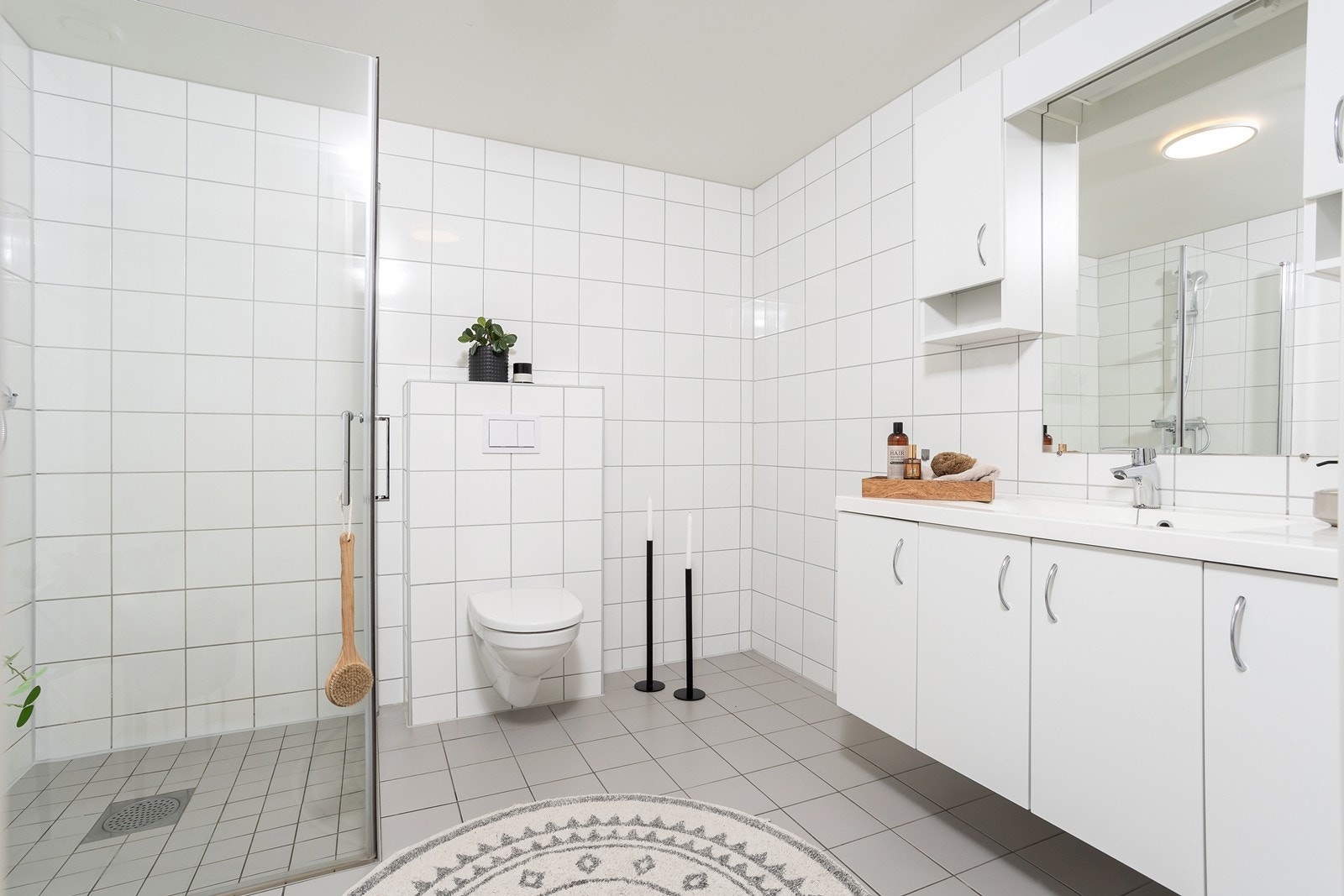 Badet er utstyrt med innredning med heldekkende servant, vegghengt toalett, dusjhjørne med glassdører, samt opplegg for vaskemaskin. Galleribilde