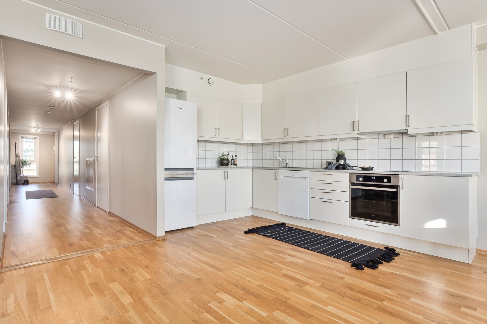 Kjøkkenet er fra den norske kvalitetsleverandøren Sigdal og har hvite, glatte fronter med laminat benkeplate. Galleribilde