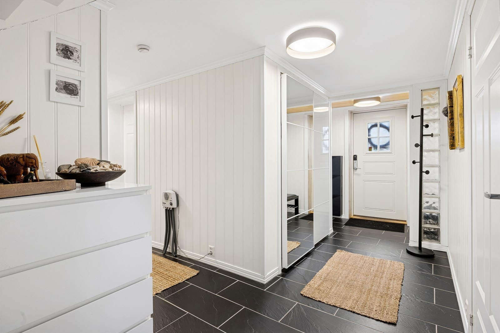 Romslig inngangsparti med god plass til å henge av seg yttertøyet. Her finner du også en praktisk skyvedørsgarderobe med speil. Galleribilde