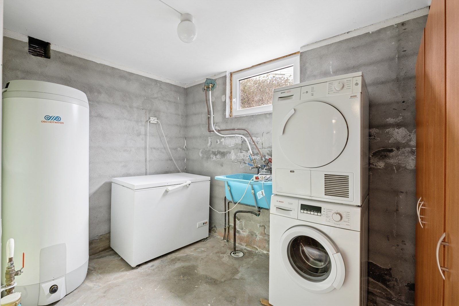 Enkelt vaskerom i kjeller med utslagsvask og opplegg for vaskemaskin. Galleribilde