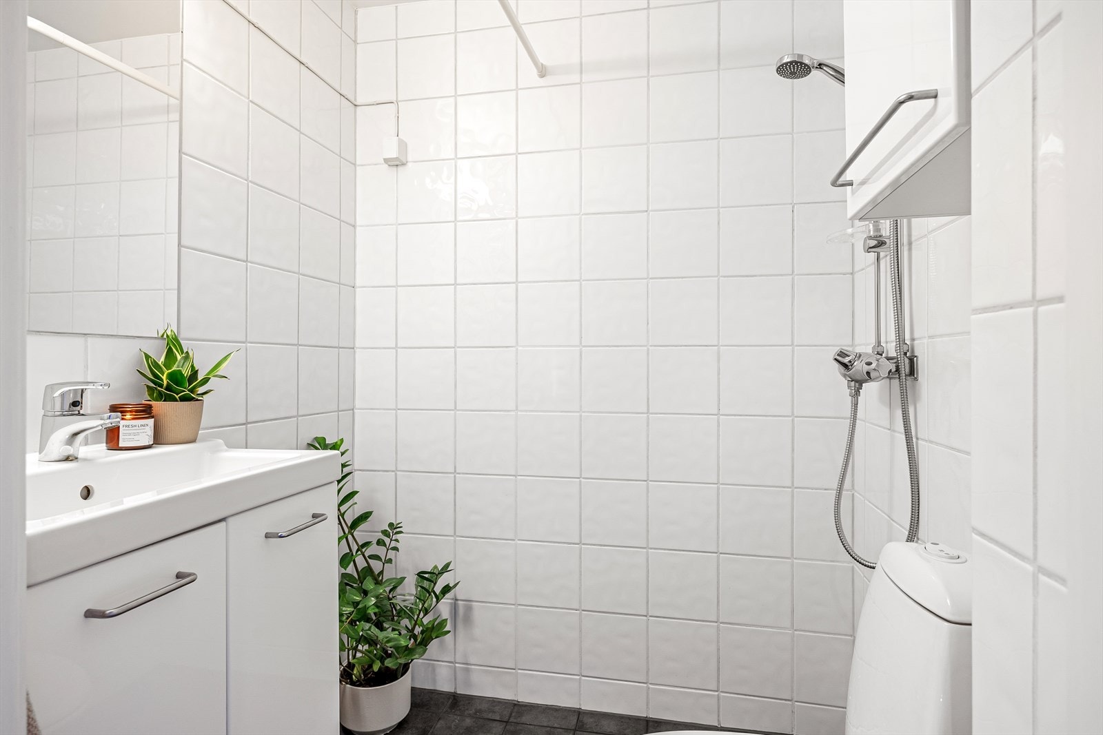 Badet består av WC, dusjplass med forheng, servant med ettgreps blandebatteri i innredning og opplegg for vaskemaskin. Galleribilde