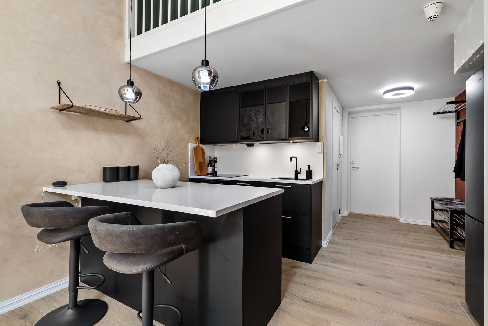 Kjøkkeninnredning har glatte fronter og benkeplate i stein med nedfelt oppvaskkum Galleribilde