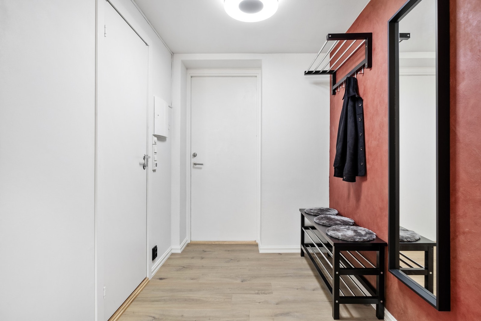 Entréen har laminat på gulv og slette flater på vegger og Phillips Hue smartlys i himling Galleribilde