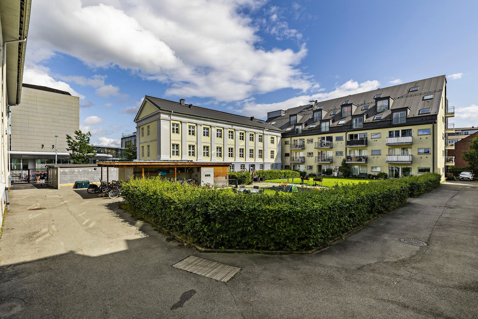 Pent opparbeidet fellesareal med lekeplass, sittegrupper, plen og beplantning Galleribilde