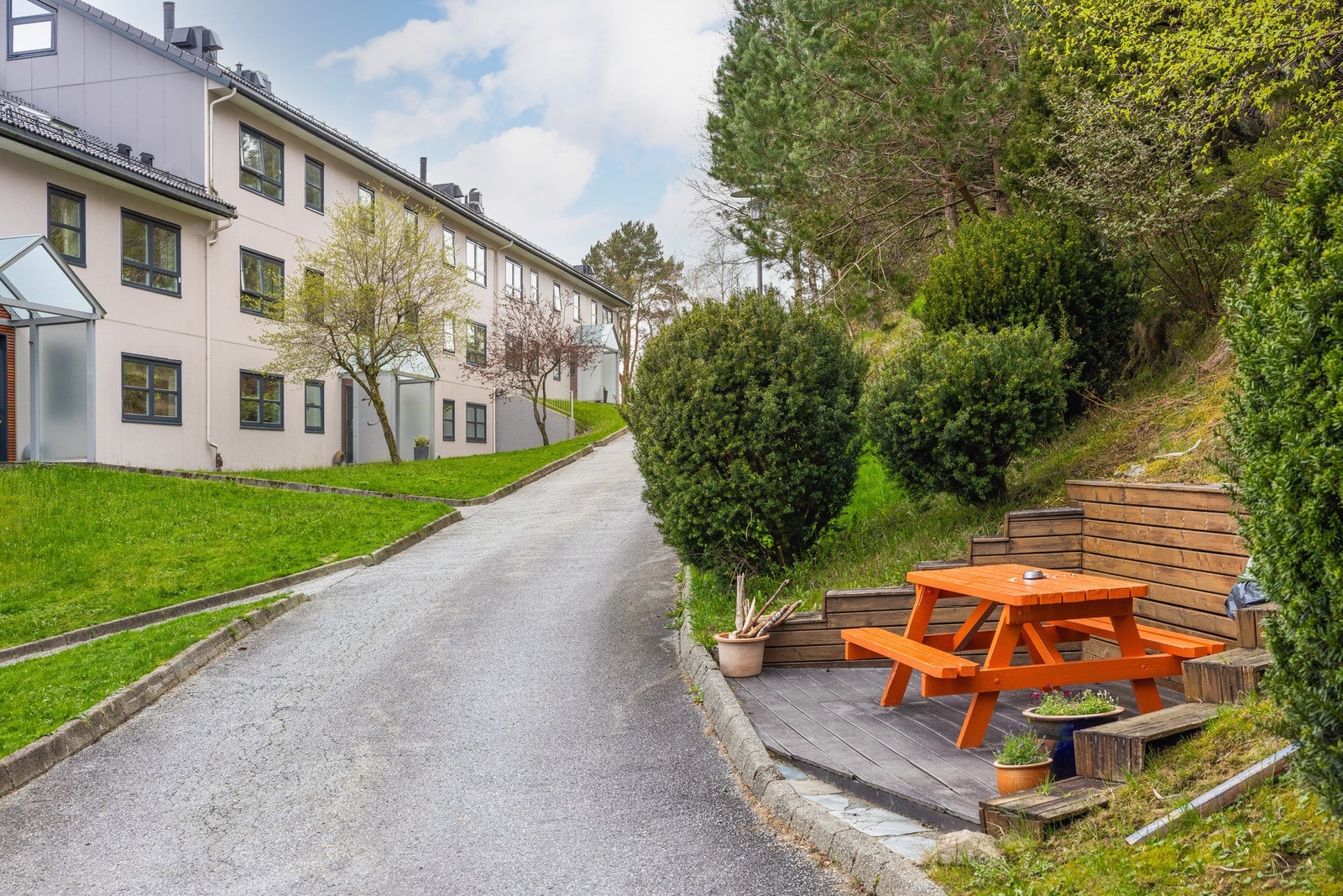 Pent opparbeidet fellesareal med grøntområder, gangveier og lekeplasser. Galleribilde