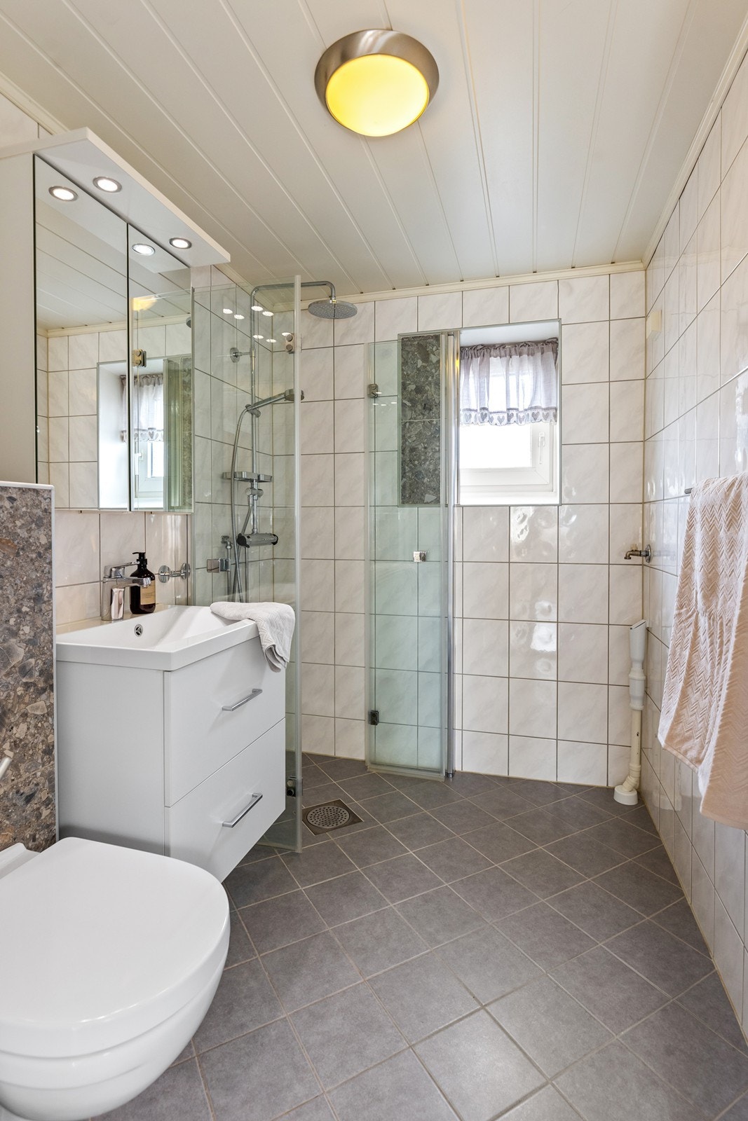 Pent flislagt bad fra 2012 med bla. dusjhjørne og opplegg for vaskemaskin Galleribilde