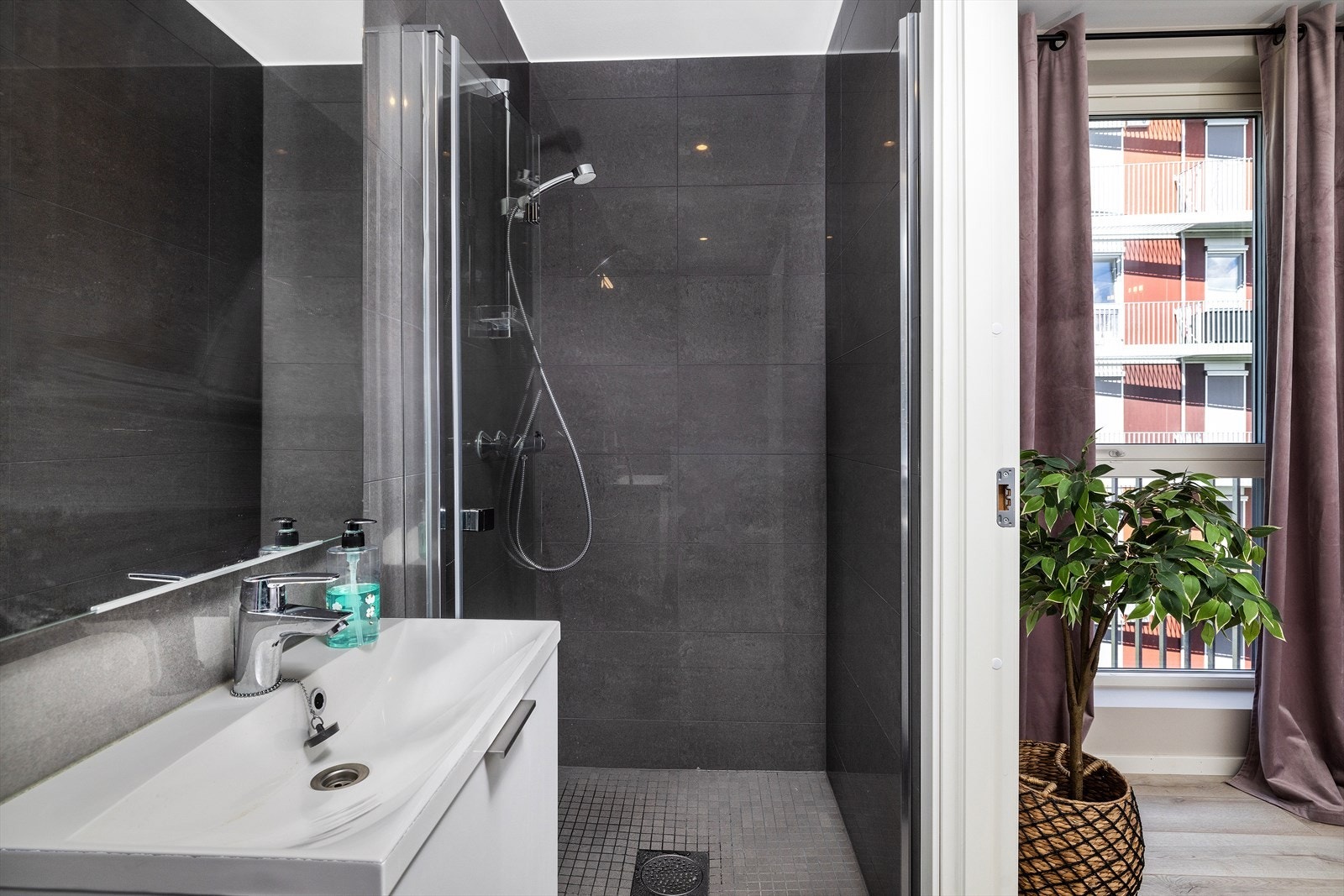 Badet til hovedsoverommet har lekker utførelse med fliser og dusjhjørne med glassdører. Galleribilde