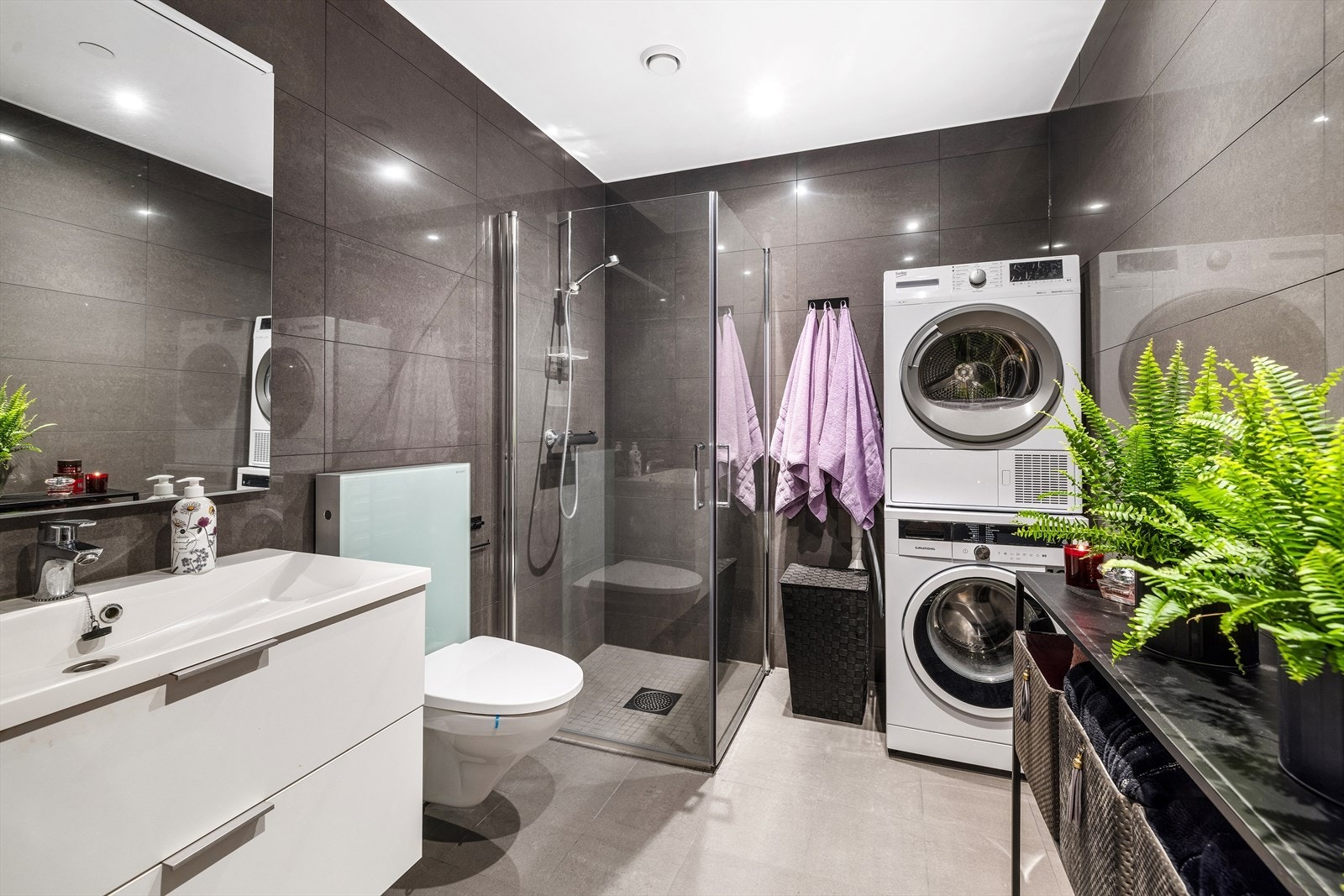 Hovedbadet har god størrelse og moderne fliser. Opplegg for vaskemaskin og tørketrommel. Galleribilde