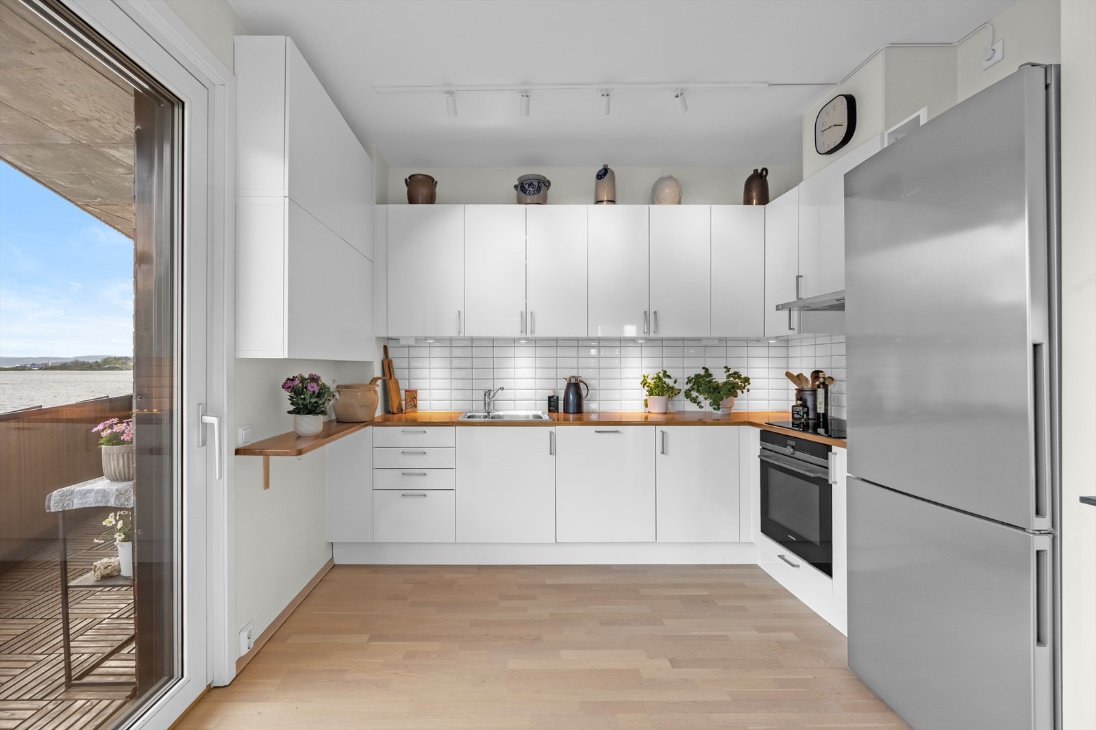 Kjøkkenet har en moderne innredning med glatte fronter. Kjøkkenet er utstyrt med integrerte hvitevarer, inkludert stekeovn, platetopp og oppvaskmaskin - alt for en praktisk og stilren løsning. Galleribilde