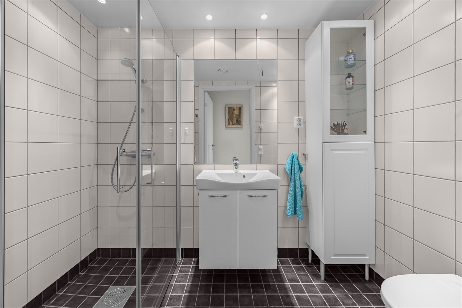 Videre har badet dusjhjørne med dører i herdet glass. Galleribilde