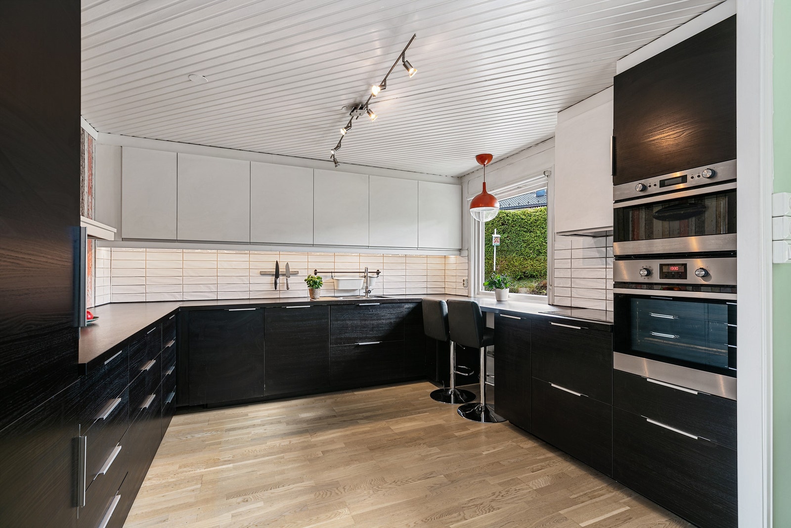 Moderne og romslig kjøkken med mye oppbevaringsplass og integrerte hvitevarer. Hyggelig frokostplass med utsikt til hagen Galleribilde