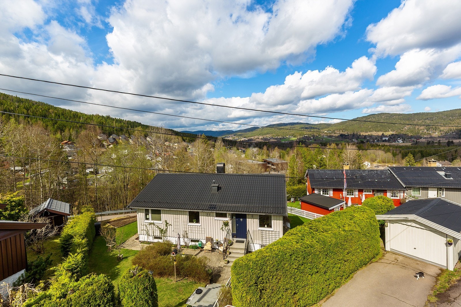 Boligen ligger fin til med vintergrønne hekker og koselig beplantning, utsikt fra eiendommen Galleribilde