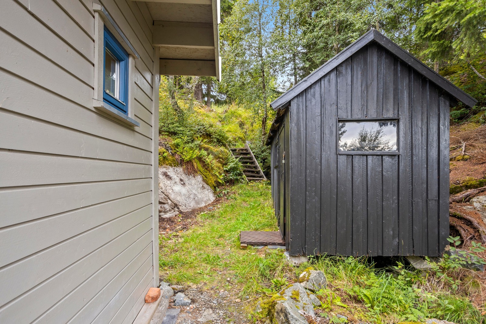 På siden av hytta er det eldre uthus, praktisk for oppbevaring. Galleribilde