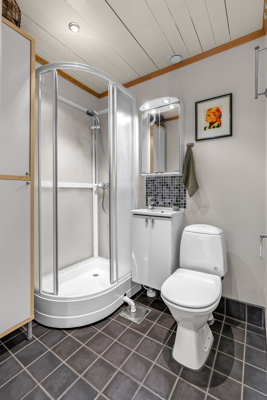 Baderom pusset opp i 2004. Rommet har varmekabler i gulvet og er utstyrt med gulvstående klosett, dusjkabinett og servant med underskap. Galleribilde