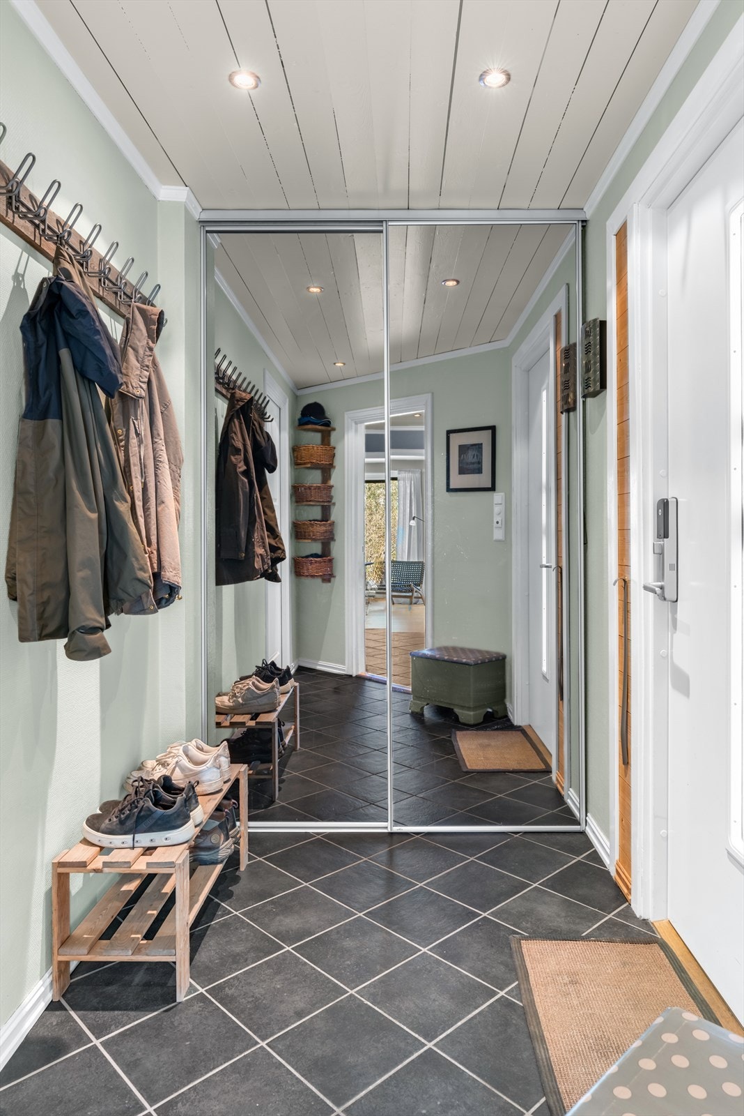Entréen har god plass til yttertøy og sko, med en praktisk skyvedørsgarderobe med speilfronter. Galleribilde