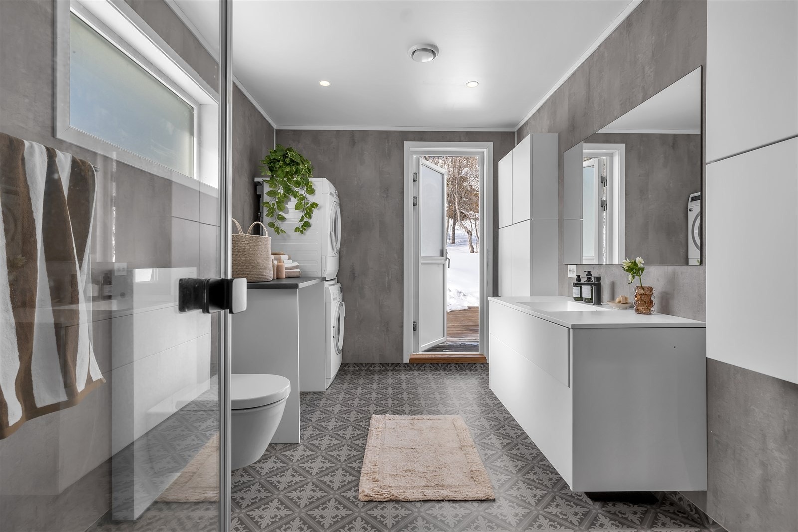 Romslig baderom m/ vaskenisje i 1. etasje med utgang til uteområde på boligens bakside. Galleribilde