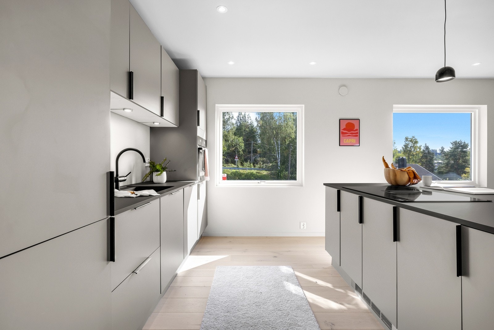 Øvrige hvitevarer består av stekeovn, oppvaskmaskin og kjøl/frys. Oppvaskkummen er i sort kompositt med sort kran, og under overskapene er det downlights. Galleribilde