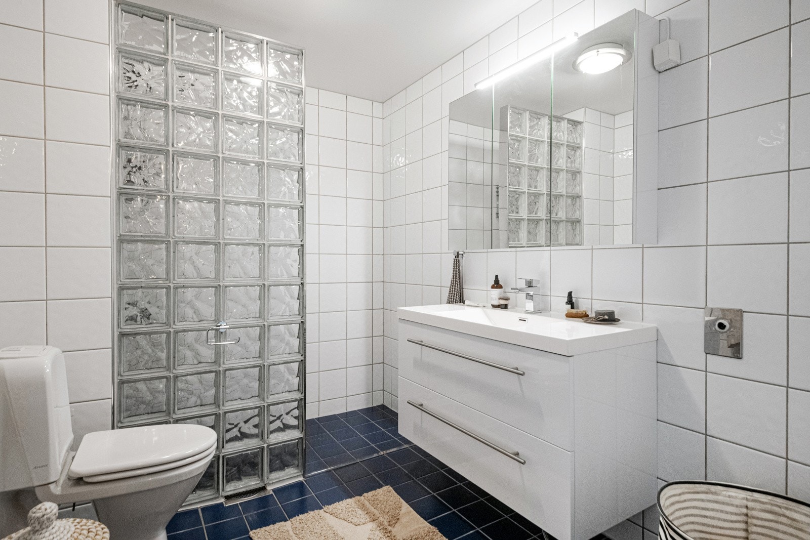 Badet består av et romslig servantmøbel med underskap, speil, toalett og dusjnisje. Det er også opplegg og plass for vaskemaskin og tørketrommel på badet, som for øvrig er av god størrelse. Galleribilde