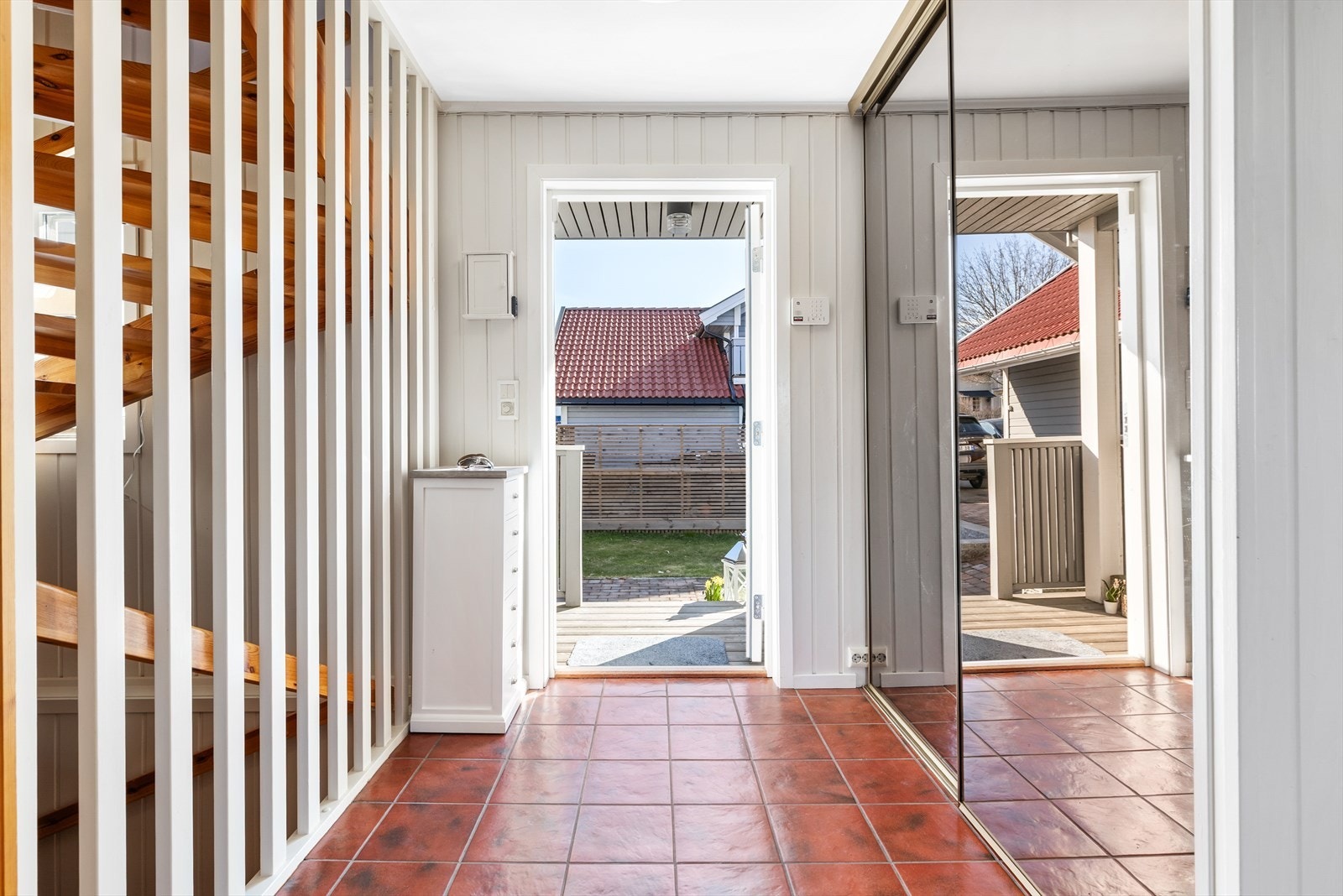 Entré med flislagt gulv og varmekabler. Tilgang til trapperom. Skyvedørsgarderobe med speilfronter for oppbevaring. Galleribilde