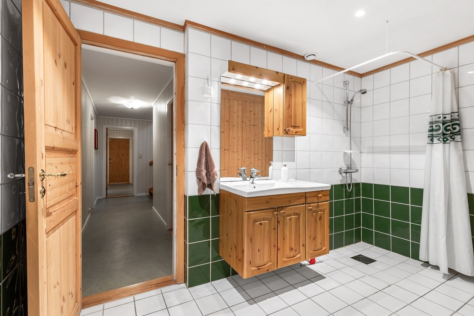 Speil og belysning i overkant av servant, varmekabler i gulv og downlights i tak. Galleribilde