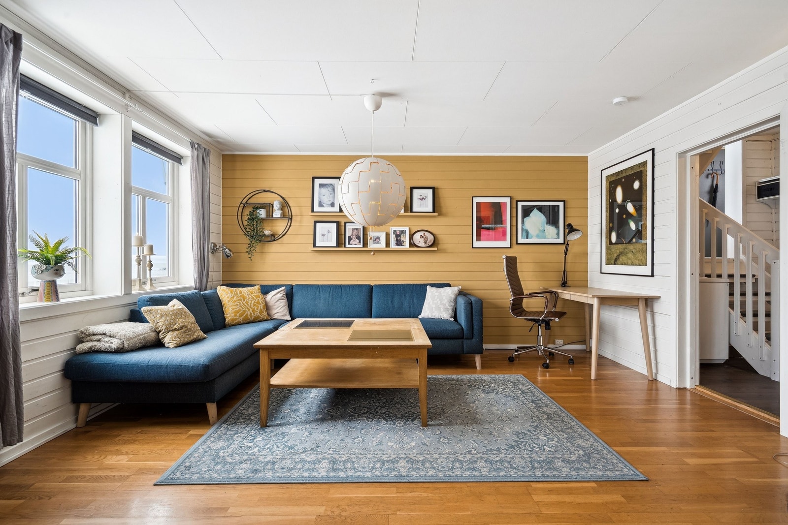 Deler av stuen er malt i en nydelig okergul farge som gir rommet en rolig og harmonisk atmosfære Galleribilde