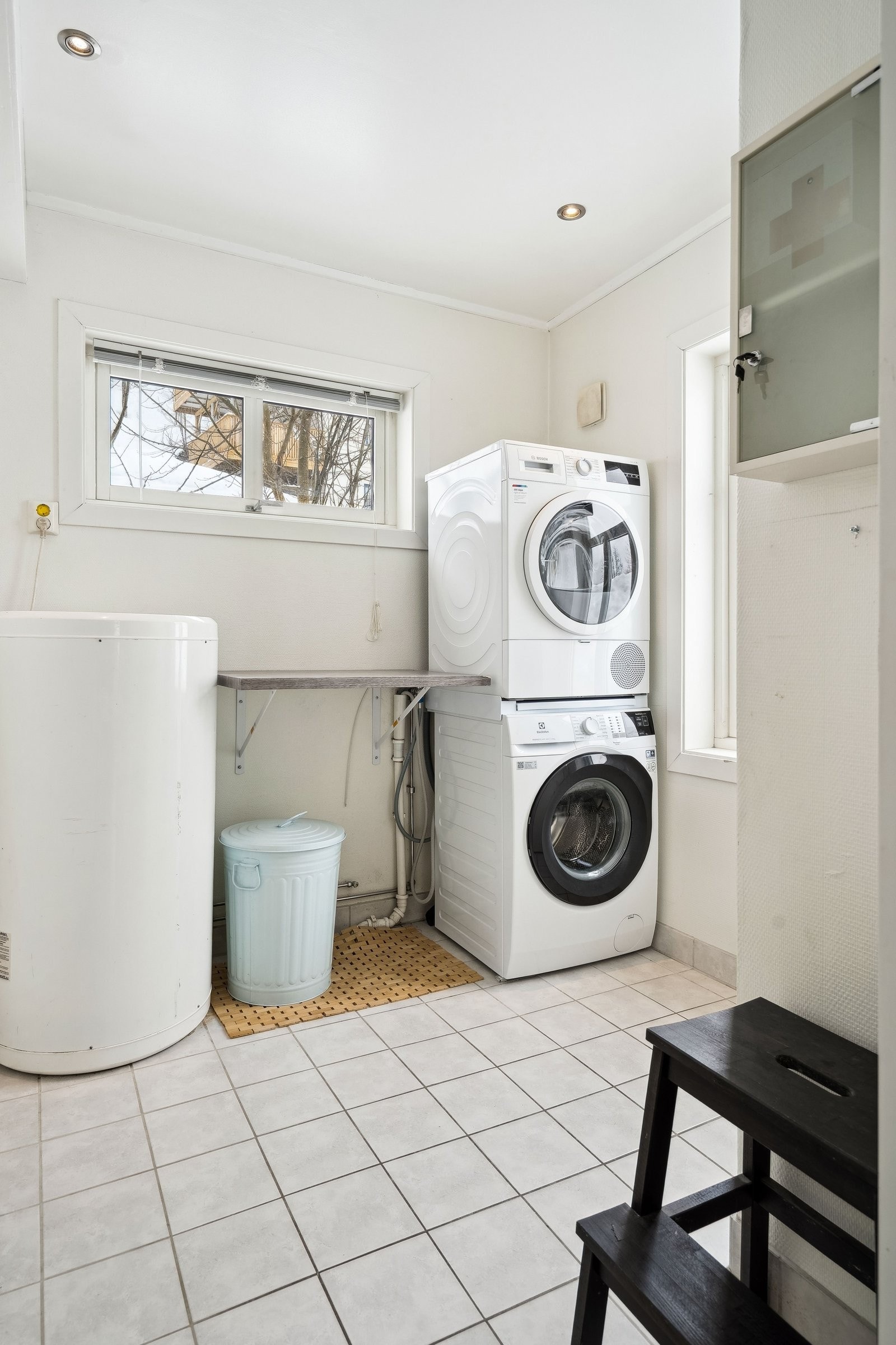 Praktisk vaskerom med opplegg for vaskemaskin og tørketrommel. Plass til oppbevaring og klær til tørk Galleribilde