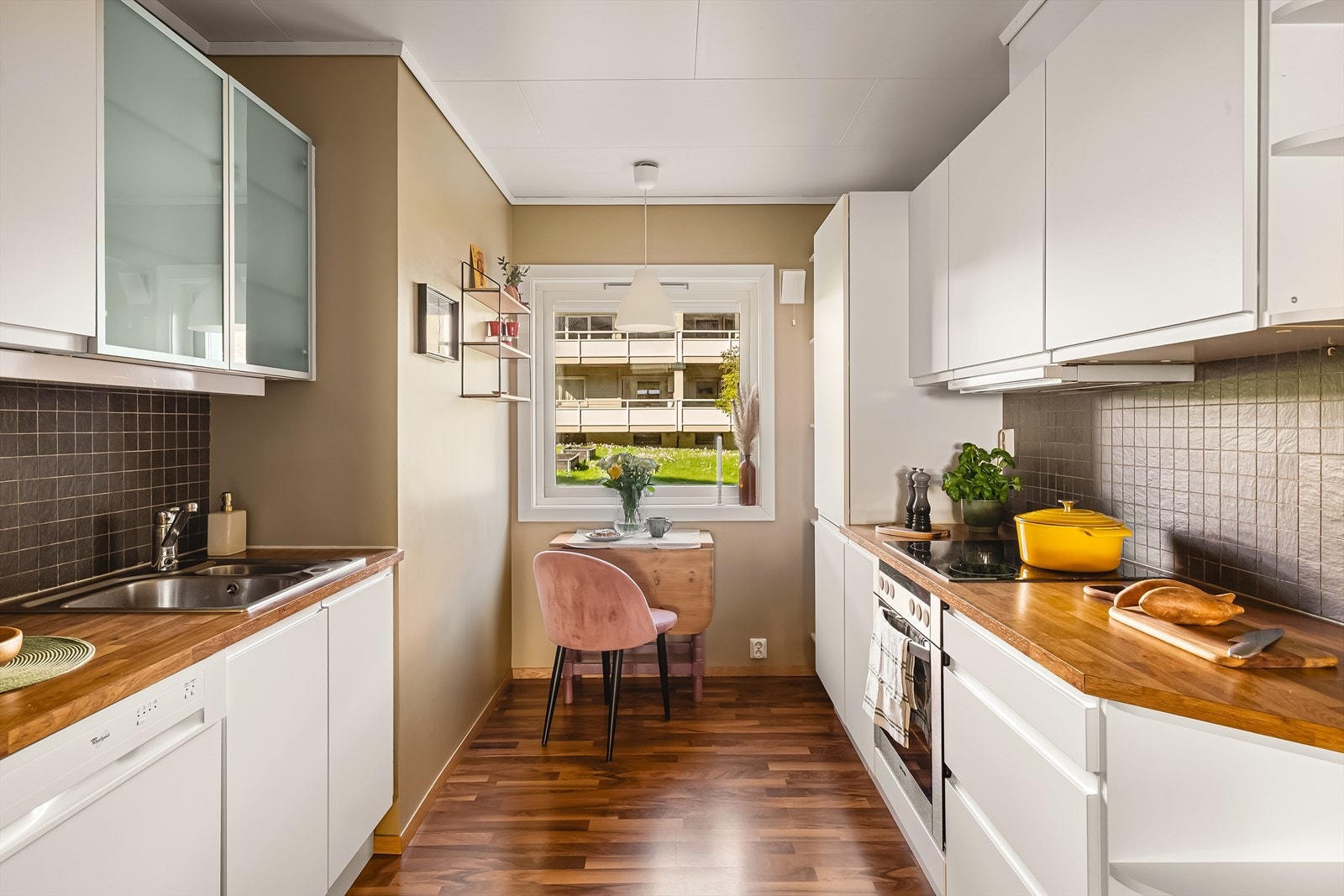 HTH-kjøkken på 7,1 kvm fra 2011 med moderne uttrykk og slette, hvite fronter - enkelte med frostet glass. Galleribilde