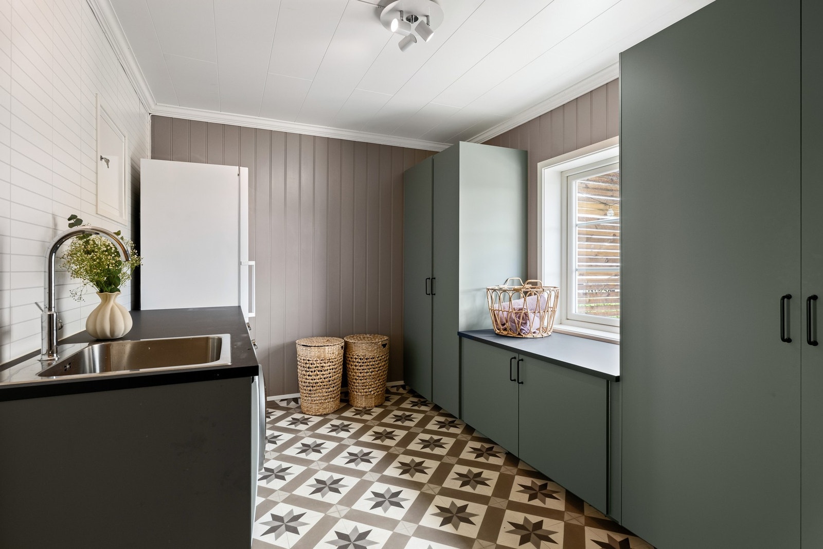 Vaskerommet har innredning med nedfelt servant og opplegg for vaskemaskin. Romslig innredning med god plass til å organisere klesvasken. Galleribilde