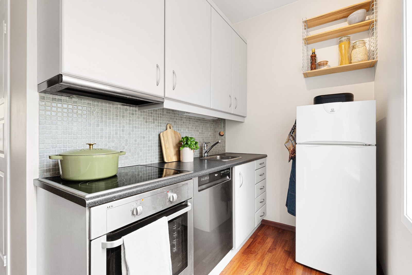 Lyst og flott kjøkken med integrert komfyr, platetopp og oppvaskmaskin. Galleribilde