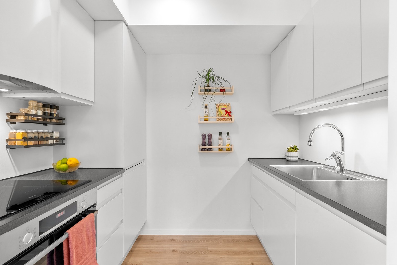 Flott og tidløst kjøkken fra 2018 med hvite slette fronter og grå benkeplate av laminat. Integrert platetopp, stekeovn, oppvaskmaskin og kjøleskap med fryser. Galleribilde