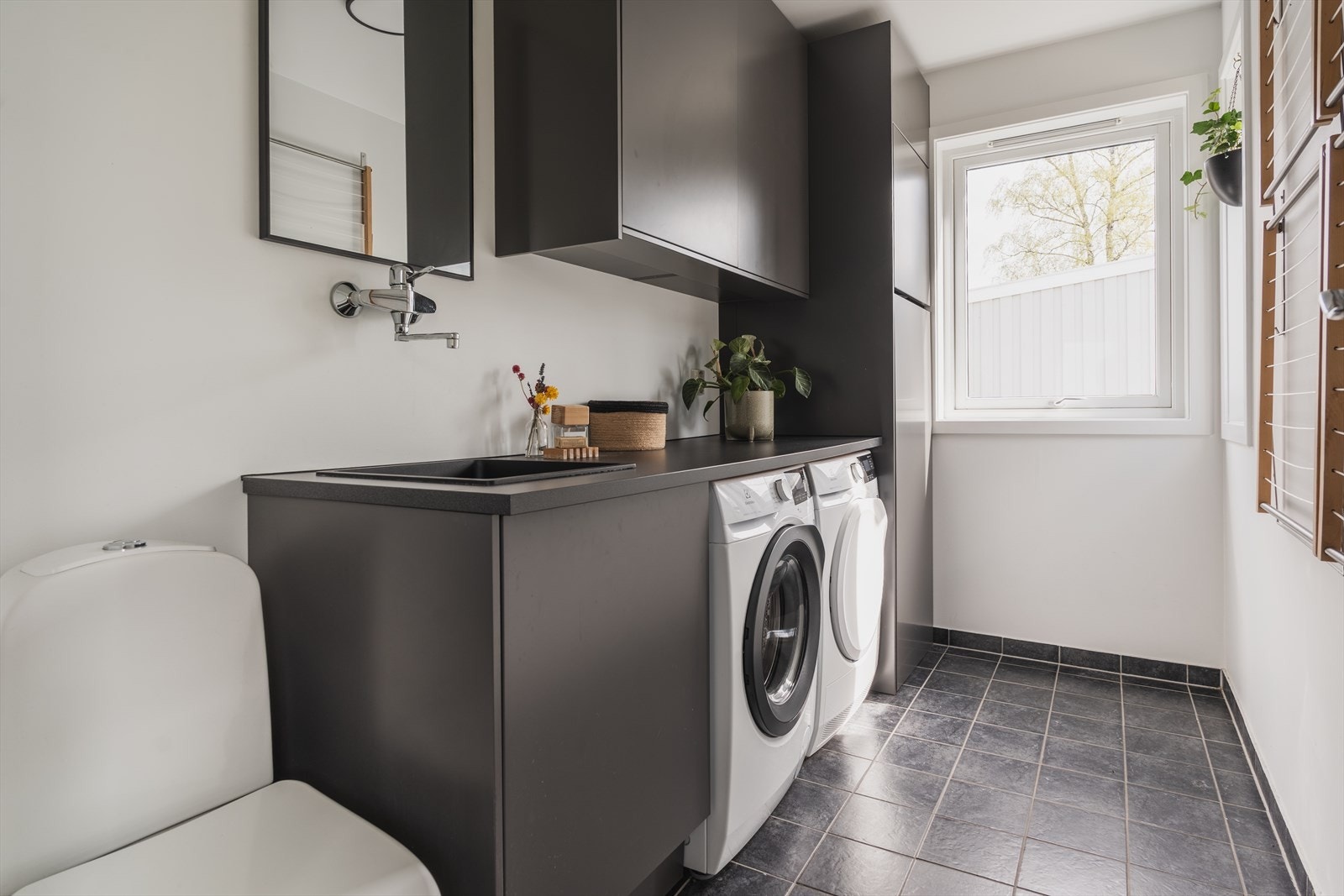 Svært praktisk vaskerom i direkte tilknytning til entré. Her går barna på flislagte gulv rett fra lekeplassen. Separat WC i tillegg Galleribilde