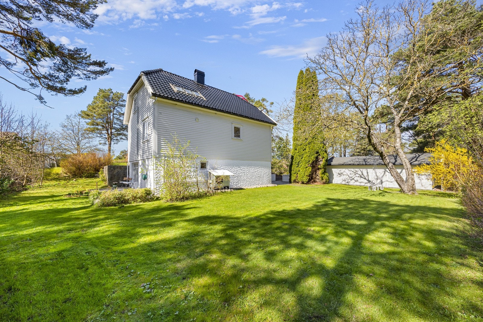 Vakker tomt opparbeidet med stort hageareal, diverse beplantinger, terrasser. God plass for diverse aktiviteter. Galleribilde