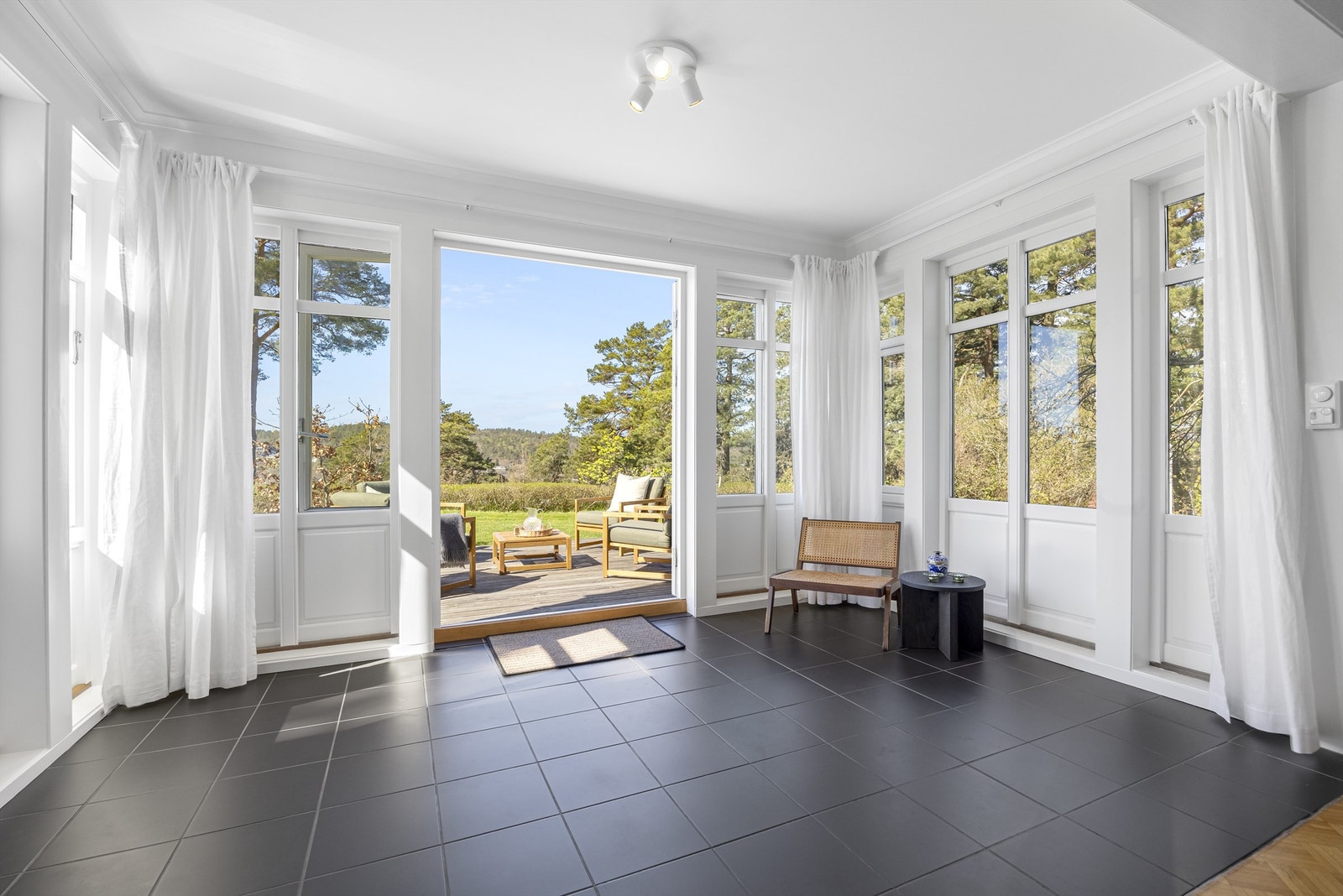 Nydelig del av stuen med naturlig lys fra alle vinkler. Galleribilde